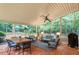 Enclosed sunroom featuring brick floors, dining area, a seating area, and views of the wooded backyard at 4521 Chicopee Trl, Durham, NC 27707