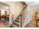 Carpeted stairway with hardwood railing and chair lift, with view to dining area at 4521 Chicopee Trl, Durham, NC 27707
