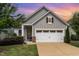 Charming single-Gathering home featuring a two-car garage, stone accents, and a well-manicured lawn at 47 Coventry Ln, Chapel Hill, NC 27516