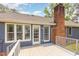 Gray stained wood deck with brick chimney and access to the home's back entry at 500 Hunters Ridge Dr, Fuquay Varina, NC 27526