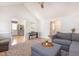 Bright living room with vaulted ceilings, gray sofa, and view into kitchen and dining room at 500 Hunters Ridge Dr, Fuquay Varina, NC 27526