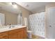 Bright bathroom with tiled floors, large mirror, shower with curtain and white cabinets at 5003 Blue Jack Oak Dr, Cary, NC 27519