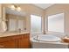 Bright bathroom with a separate tub, marbled countertops, and double windows for natural light at 5003 Blue Jack Oak Dr, Cary, NC 27519