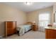 Comfortable bedroom featuring a twin bed, wood dressers, and bright windows for natural light at 5003 Blue Jack Oak Dr, Cary, NC 27519