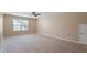 Bright carpeted bedroom featuring large window with ceiling fan and easy access to the thermostat at 5003 Blue Jack Oak Dr, Cary, NC 27519