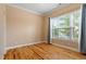 Bright, empty bedroom with hardwood floors, a large window, and neutral walls at 5003 Blue Jack Oak Dr, Cary, NC 27519