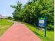 Nancy Branch Greenway trail entrance with brick pathway, greenway sign, and lush greenery in Amberly at 5003 Blue Jack Oak Dr, Cary, NC 27519
