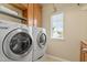 Convenient laundry room with front load washer and dryer, storage and window at 5003 Blue Jack Oak Dr, Cary, NC 27519