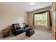 Neutral living room with large window, with carpet floors, sofa and ottoman at 5003 Blue Jack Oak Dr, Cary, NC 27519