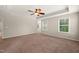 Large carpeted bedroom featuring a tray ceiling and natural light at 5011 Peachtree Town Ln, Knightdale, NC 27545