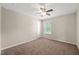 Sunny bedroom features large window, plush carpeting, and ceiling fan at 5011 Peachtree Town Ln, Knightdale, NC 27545
