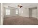Large carpeted bedroom featuring a tray ceiling and two sunny windows at 5011 Peachtree Town Ln, Knightdale, NC 27545