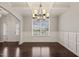 Dining room with wainscoting, hardwood floors and decorative chandelier at 5011 Peachtree Town Ln, Knightdale, NC 27545
