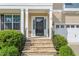 Inviting front entrance with stone steps, columns, and decorative black railings at 5011 Peachtree Town Ln, Knightdale, NC 27545