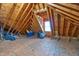 Bright attic space featuring exposed wooden beams, plywood flooring, and a window for natural light and ventilation at 5016 Swordfish Dr, Raleigh, NC 27603