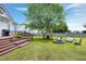 Relaxing backyard with a wooden deck, green lawn, firepit, mature tree, and comfortable outdoor seating at 5016 Swordfish Dr, Raleigh, NC 27603