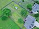 Aerial view of large backyard with a shed, garden beds, a fire pit, a deck, and mature trees at 5016 Swordfish Dr, Raleigh, NC 27603