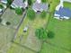 An aerial view of a spacious backyard with mature trees, a shed, garden beds, and fire pit seating at 5016 Swordfish Dr, Raleigh, NC 27603