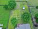 Aerial view of the backyard, featuring a shed, garden beds, mature trees, a fire pit and a deck at 5016 Swordfish Dr, Raleigh, NC 27603