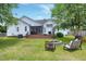 Spacious backyard with a fire pit, outdoor seating, a wooden deck, and lush green grass at 5016 Swordfish Dr, Raleigh, NC 27603