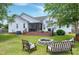 Landscaped backyard featuring a fire pit with seating, a spacious deck, and a well-maintained lawn at 5016 Swordfish Dr, Raleigh, NC 27603