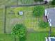 Aerial view of backyard with a shed, trees, garden beds, a fire pit, and a wooden fence at 5016 Swordfish Dr, Raleigh, NC 27603