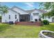 Inviting backyard showcasing a screened porch, wooden deck with potted plants, and a charming fire pit seating area at 5016 Swordfish Dr, Raleigh, NC 27603