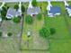 Aerial view of a large backyard with a shed, garden beds, mature trees, and a fire pit area at 5016 Swordfish Dr, Raleigh, NC 27603