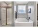 Well-lit bathroom featuring shower and bath tub, and glass block window for privacy and natural light at 5016 Swordfish Dr, Raleigh, NC 27603