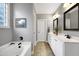Bathroom featuring dual sinks, tile floors, bathtub, and a decorative bear themed picture on the wall at 5016 Swordfish Dr, Raleigh, NC 27603
