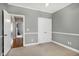 Bedroom featuring carpet, white trim, double door closet, and view into another room with hardwood floors at 5016 Swordfish Dr, Raleigh, NC 27603