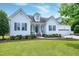 Charming white two-story home with dark shutters, manicured lawn, and beautiful landscaping at 5016 Swordfish Dr, Raleigh, NC 27603