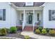 Inviting front porch featuring a glass front door, chair seating, and beautiful landscaping at 5016 Swordfish Dr, Raleigh, NC 27603