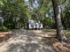Inviting home nestled among lush trees, accessible via a long, paved driveway at 503 Pine Run, Knightdale, NC 27545