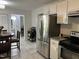 Bright eat-in kitchen features stainless steel appliances, white cabinets, and neutral tile flooring at 503 Pine Run, Knightdale, NC 27545