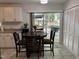 Eat-in kitchen with white cabinets, tile flooring, and a dining area with a dark round table at 503 Pine Run, Knightdale, NC 27545