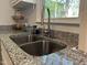 Stainless steel double sink with granite countertops, with a view through the kitchen window at 503 Pine Run, Knightdale, NC 27545