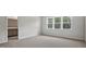 Bright bedroom offers large window with wooded view, and neutral carpet at 510 Resteasy Dr, Apex, NC 27539
