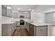 Open kitchen boasts gray cabinets, stainless steel appliances, and a large center island with quartz countertops at 510 Resteasy Dr, Apex, NC 27539