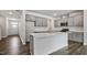 Well-lit kitchen features gray cabinets, a center island, stainless appliances, and flows into adjacent rooms at 510 Resteasy Dr, Apex, NC 27539