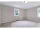 Bedroom featuring neutral colored walls, carpet flooring, and natural light from the two windows at 5121 Raintree Rd, Durham, NC 27712