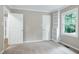Bedroom with a window and built in shelving, featuring neutral walls and carpet flooring at 5121 Raintree Rd, Durham, NC 27712