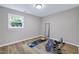 Bright bedroom with wood flooring, a large window, and a mirror, perfect for workouts at 5121 Raintree Rd, Durham, NC 27712