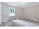 Bedroom with neutral walls, carpet flooring, a window that provides natural light, and a built-in shelving unit at 5121 Raintree Rd, Durham, NC 27712