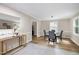Light-filled dining room with modern furniture and open access to the kitchen at 5121 Raintree Rd, Durham, NC 27712