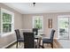 Light-filled dining room with modern furniture and large windows providing natural light at 5121 Raintree Rd, Durham, NC 27712
