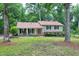Traditional two-story home with a welcoming front porch and a red front door surrounded by a lush lawn and mature trees at 5121 Raintree Rd, Durham, NC 27712