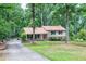 Traditional two-story home with a welcoming front porch and a long driveway surrounded by mature trees at 5121 Raintree Rd, Durham, NC 27712