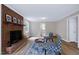 Inviting living room showcases brick fireplace, wood flooring, and comfortable seating arrangement at 5121 Raintree Rd, Durham, NC 27712