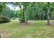 Spacious front yard with mature trees, offering ample outdoor space and a serene, natural setting at 5121 Raintree Rd, Durham, NC 27712